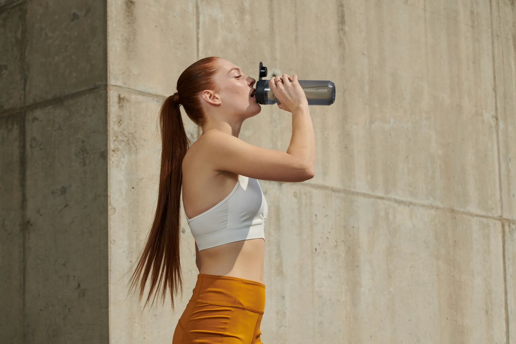 Woman drinking water after work out