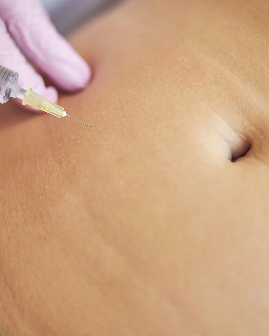An injection being administered to an abdomen