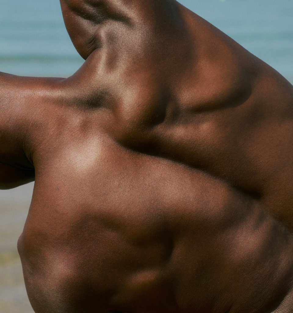 A closeup of a man's back while he is stretching