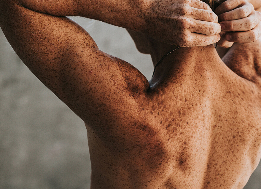 Back view of a shirtless man stretching