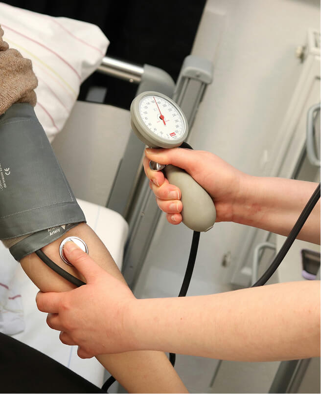 a healthcare professional measuring a patient's blood pressure
